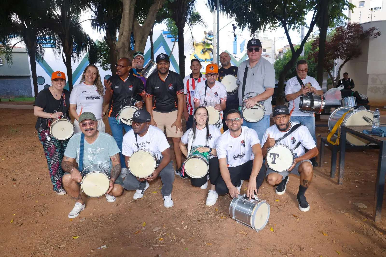 Grupo de alunos do Só para Cuícas reunidos ao ar livre segurando suas cuícas